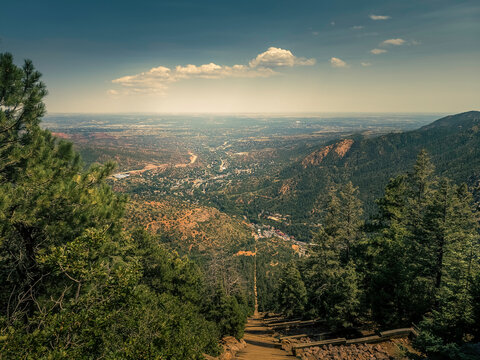 Breathtaking view from the summit of the Manitou Incline overlooking the city of Colorado Springs. The image captures rocky mountain terrain in the foreground with a sea of clouds rolling below.
