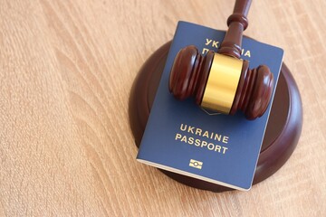 Judge gavel and ukrainian passport on brown background. Passport Of Ukraine. Obtain citizenship