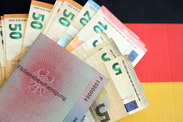 German temporary Permanent resident card specimen and euro money bills lies on German flag close up. Fiktionsbescheinigung