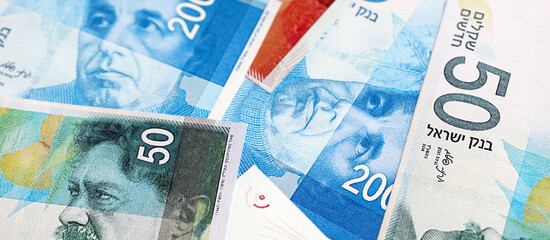 Israel New Shekels banknotes. The current Israel money bills lies on table in big amount. The concept of business and investment in Israel