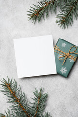 New Year or Christmas square card mockup with gift box and evergreen pine tree branches on a...
