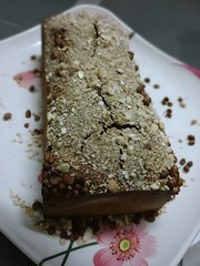 Homemade jaggery cake topped with crushed puffed rice and nuts, blending traditional Indian flavors with a modern dessert twist.