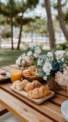 A beautifully arranged outdoor breakfast table displays fresh food and drinks, surrounded by greenery and peaceful scenery