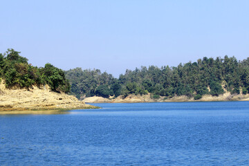 Green Hills and Sparkling Lake under Blue Sky