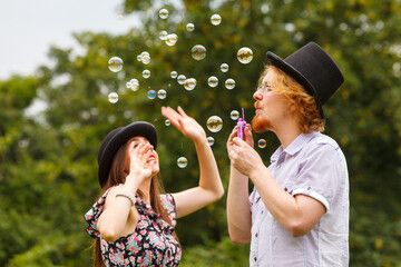 Couple blowing soap bubbles, having fun