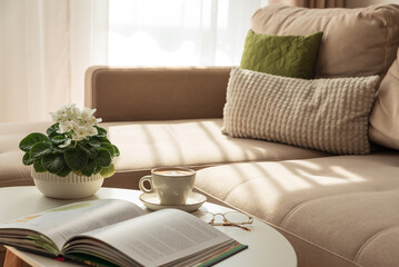 Cozy Living Room with Coffee, Book and African Violet on Table
