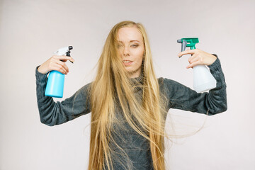 Female messy long hair holds spray bottle