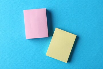 Blank colorful notes on light blue background, top view. Space for text