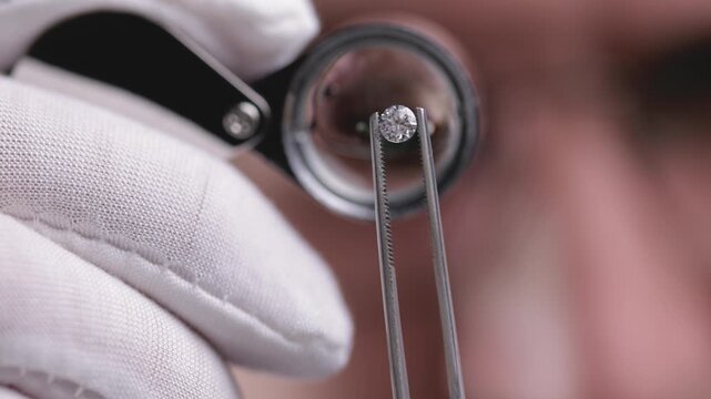 Expert gemstone inspection through magnifying glass: detailed analysis and evaluation techniques for business investment.
