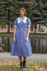 Fototapeta premium Portrait of a young woman in a blue dress with a white collar
