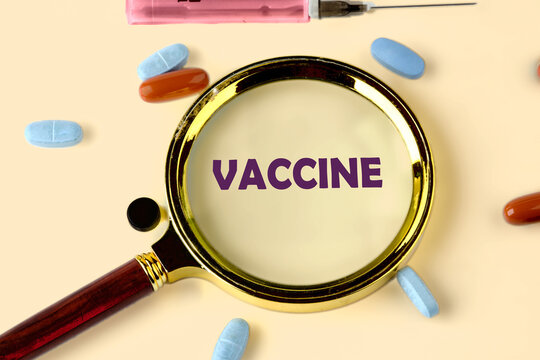A magnifying glass focuses on the word vaccine, surrounded by colorful pills and a syringe. This scene emphasizes the significance of vaccinations in health and wellness