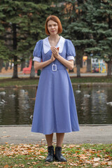 Portrait of a young woman in a blue dress with a white collar