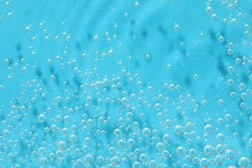 Many water bubbles on light blue background, top view