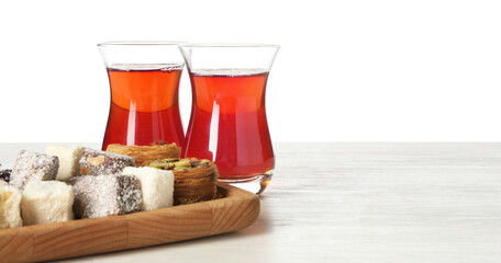 Traditional Turkish tea and desserts on wooden table against white background