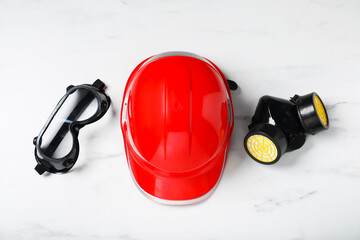 Different safety equipment on white marble table, flat lay