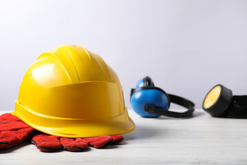 Different safety equipment on white wooden table, selective focus. Space for text