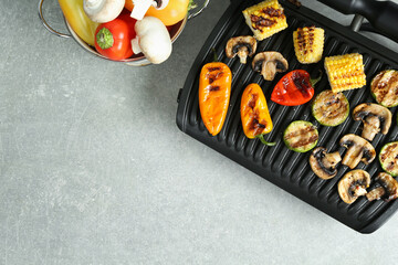 Electric grill with delicious vegetables on light table, flat lay. Space for text