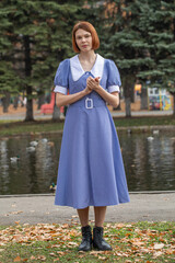 Portrait of a young woman in a blue dress with a white collar