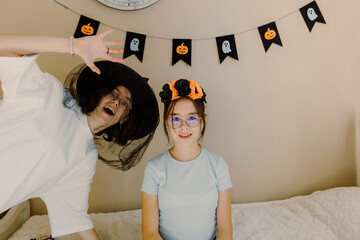 Two sisters are fooling around while celebrating Halloween.