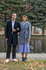 A young couple poses in an autumn park