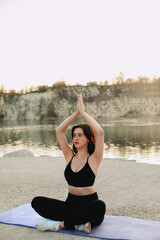 Yoga practice at sunset by the lakeside with a serene backdrop of cliffs and calm water