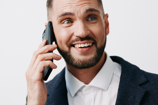A professional business man on a bright colored isolated background, projecting confident emotion while talking on a mobile phone during a work day.