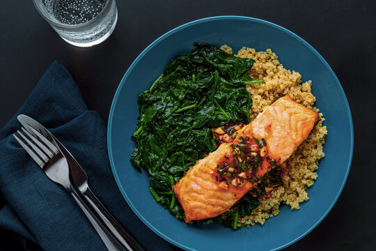 Baked Salmon Fillet on Bed of Quinoa and Wilted Spinach. Flat Lay.
