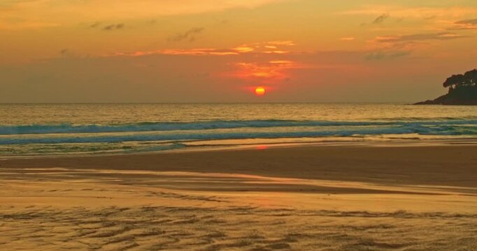Aerial view of Reflections of sunset sky dance on the wet sand, mirroring the sky&rsquo;s colorful glow. The gentle roar of the waves harmonizes with the whispering wind. beautiful Karon beach at sunset.