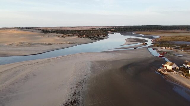 El r&iacute;o se une al mar, en la costa al amanecer con gaviotas