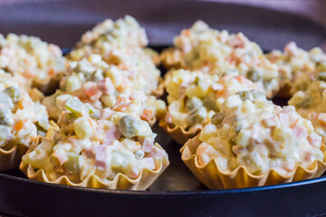 tortelets with Russian Olivier salad. appetizers with salad. decoration of a festive table. children's party. close-up. screensaver.