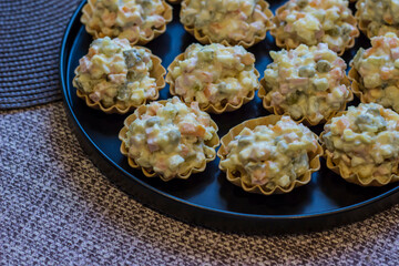 tortelets with Russian Olivier salad. appetizers with salad. decoration of a festive table. children's party. close-up. screensaver.