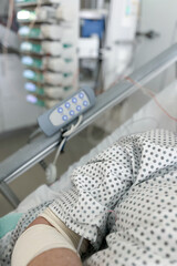 Hospital patient resting in bed with IV line and medical equipment in the background, showing a calm and clinical healthcare environment.
