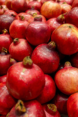 Fresh red pomegranates stacked in grocery market close-up