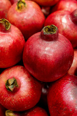 Fresh red pomegranates stacked in grocery market close-up