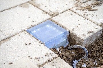 Installation of illuminated paving tiles on pavement, outdoor electrical junction box on pavement, infrastructure element. Maintenance, design of infrastructure projects. Real photo
