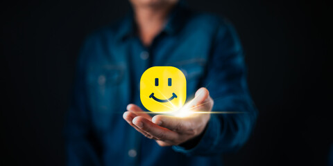 A person holding a glowing smile face icon symbolizes customer satisfaction, positive feedback, happiness, and quality service in business success and relationship management.
