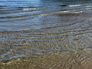 Shallow ripples on sea calm water surface.