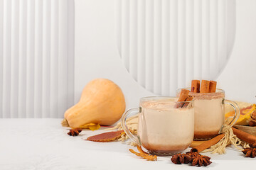 Seasonal abstract composition with hot autumn drink, warming pumpkin latte with cinnamon, star anise and fallen leaves, banner for screen, autumn greeting concept, cafe menu mockup.