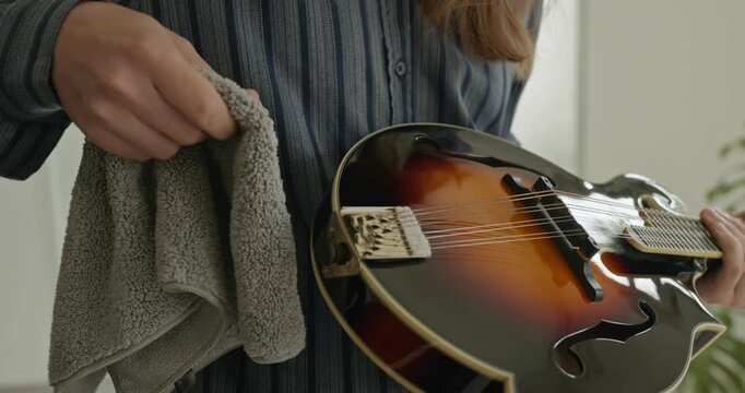 Male Musician Diligently Take Care of Instrument. Wipe Dust from Mandolin 4K 10-bit