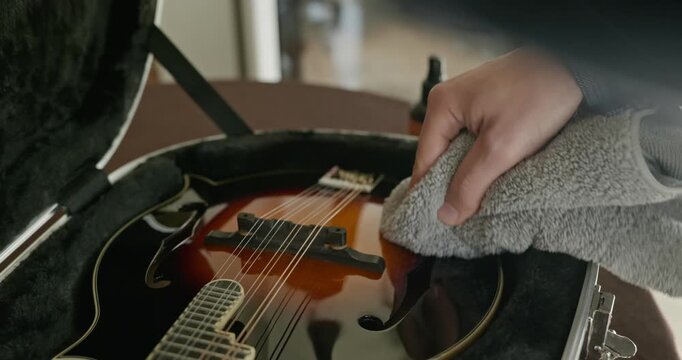 Male Musician Diligently Take Care of Instrument. Wipe Dust from Mandolin 4K 10-bit