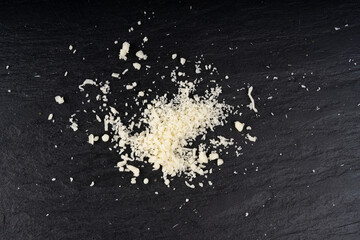 Grated mozzarella cheese on black background. Shredded mozarella texture