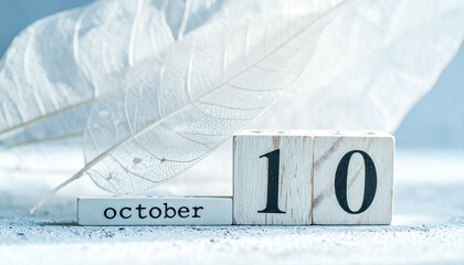 Skeleton leaves with wooden October 10 blocks on concrete surface