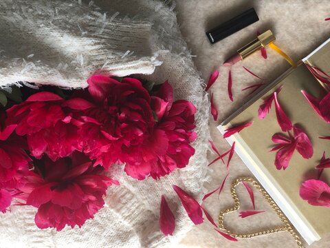 Pink peonies in the arms of a sweater