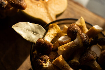 Honey mushrooms with bay leaves and quince on a rustic wooden table