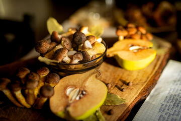 Honey mushrooms with bay leaves and quince on a rustic wooden table