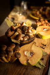 Honey mushrooms with bay leaves and quince on a rustic wooden table