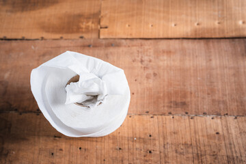 Worn toilet paper on an old wooden table
