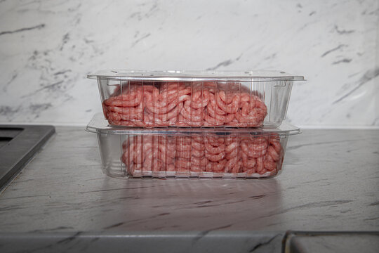 Fresh minced meat packed in plastic trays on a supermarket shelf - Powered by Adobe