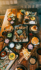 A table full of food including a variety of sandwiches, chicken, and fries