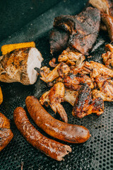 A plate of food with a variety of meats and vegetables, including chicken wings